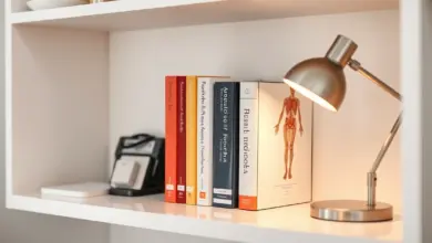 Estante de consultório com livros de referência e luminária, em tons neutros
