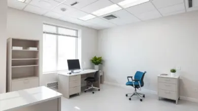 Consultório médico vazio e iluminado por luz natural, com mesa e monitor
