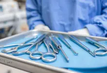 Instrumentais cirúrgicos estéreis dispostos sobre campo azul em bandeja